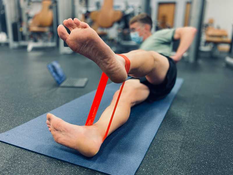 Man lying on his side doing virtual physical therapy exercises