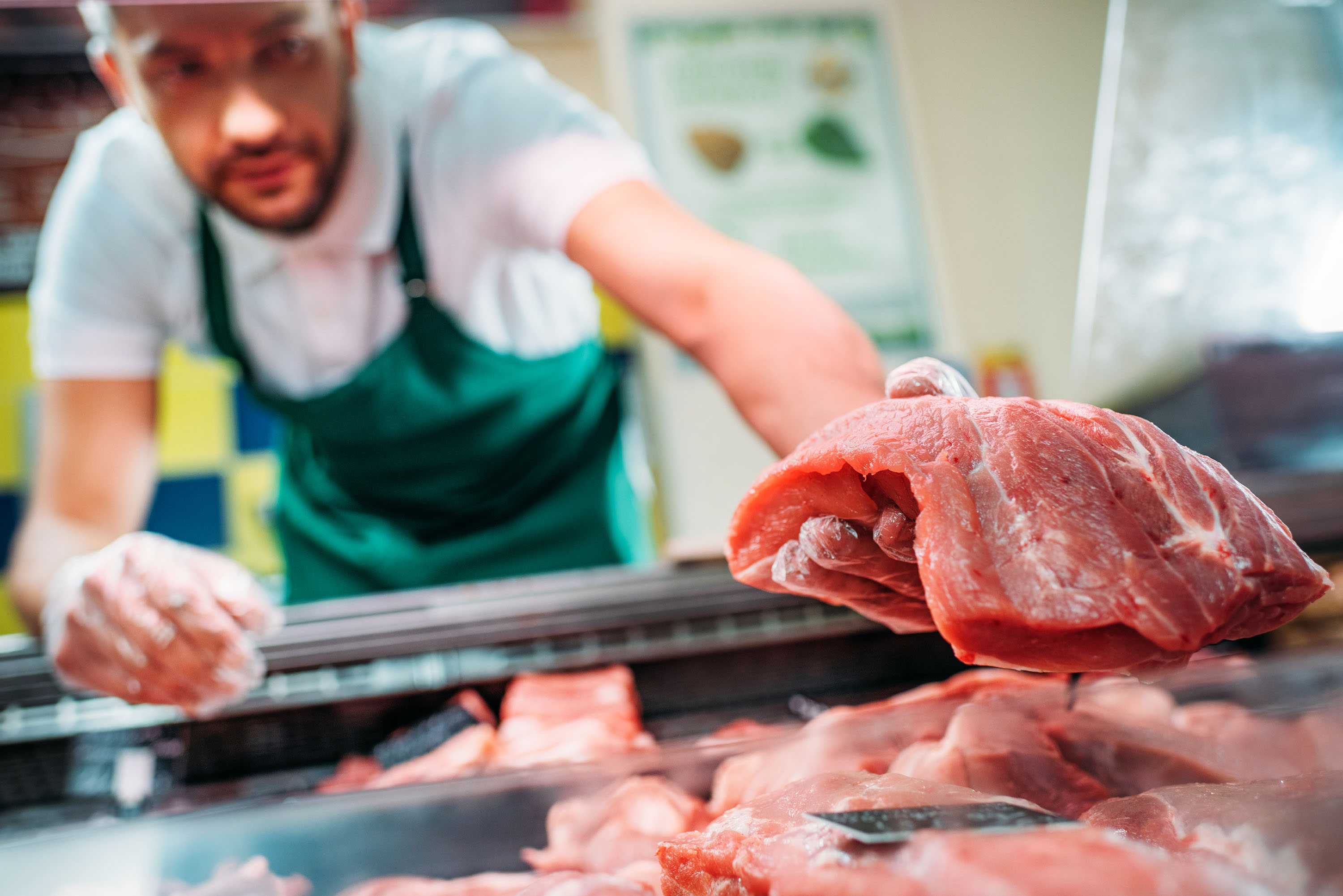 Butcher placing meat into a case